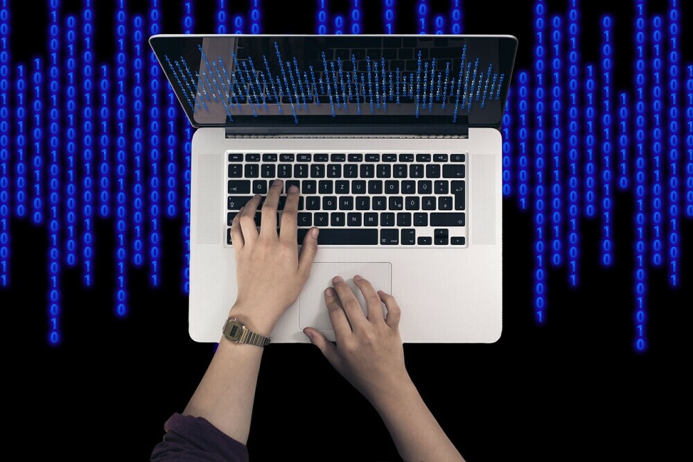 blue binary code behind laptop