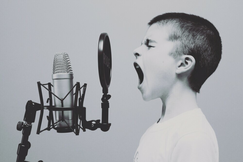 Shouting boy recording on mic