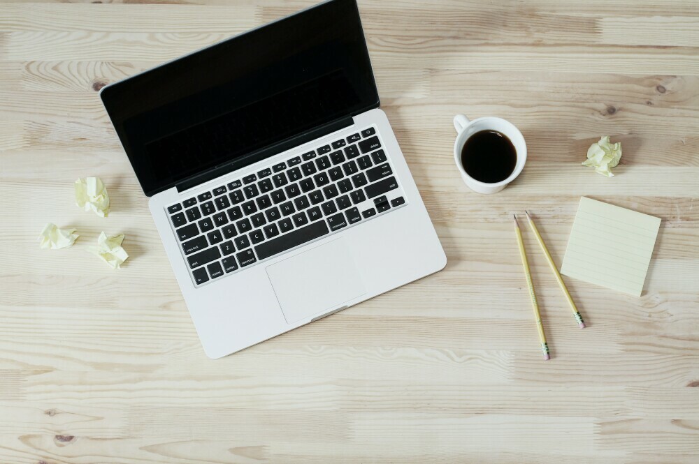 Laptop with coffee, note paper.